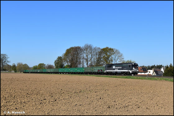 Am 29. April 2026 schleppt 264 009-2 einen leeren Sandzug durch Hartha nach Kayna