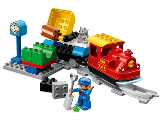 Im Paket Lego 10874 Dampfeisenbahn SET sind 59 Einzelteile, eine Dampflok, ein Lokführer, eine Kinderfigur, ein Passagierwaggon und diverse DUPLO Steine und jede Menge Schienenelemente enthalten.