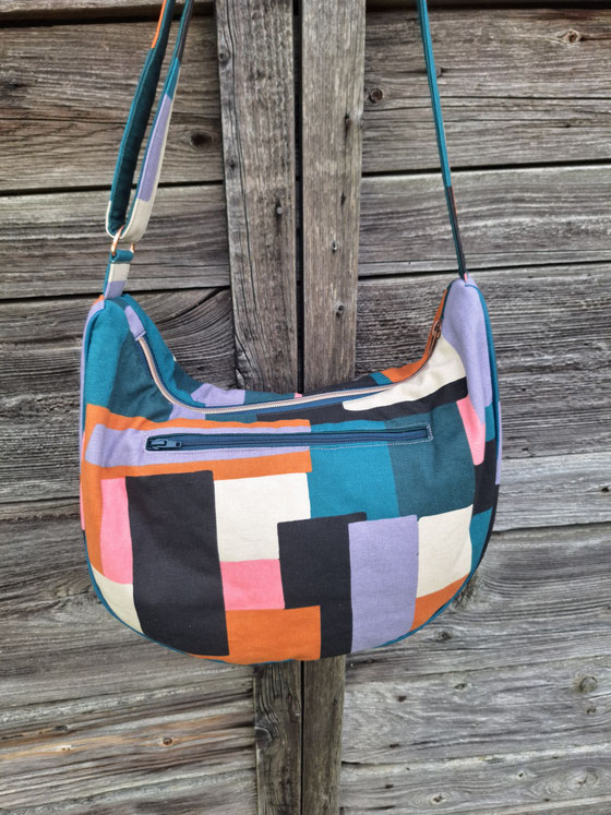 grand sac à bandoulière demi-lune femme, motif géométrique abstrait, vert canard, bleu pétrole , terracotta , noir