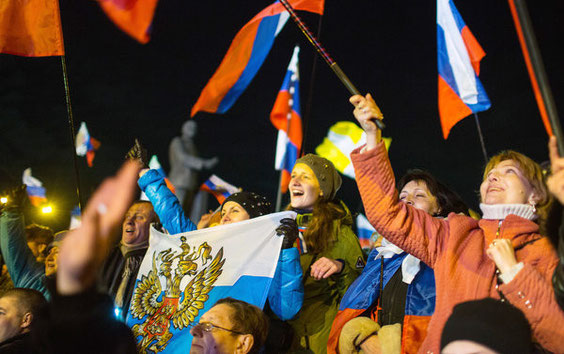 Menschen jubeln nach dem Ende des Referendums auf dem Lenin-Platz in Simferopol auf der Krim-Halbinsel in der Ukraine. Am Sonntag haben mehr als 1,8 Millionen Krim-Bewohner in einem Referendum über den Anschluss an Russland abgestimmt. Foto: dpa