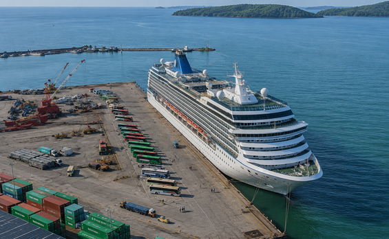 Sihanoukville cruise port with ship docked at industrial pier and shuttle buses waiting nearby