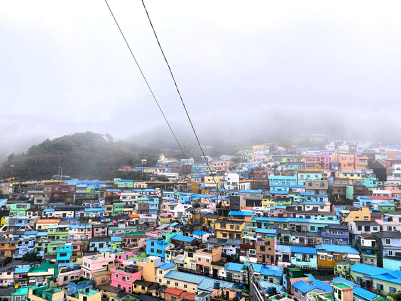 tetti delle case del quartiere ppopolare di Gamcheon a Busan, per lo più colorati di azzurro e nebbia fitta tra le colline all'orizzonte