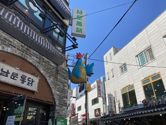 scorcio della chicken street, con insegna di un pollo sopra un ristorante di pollo fritto coreano, a Suwon