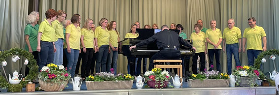 Auf der Bühne: Oliver am Flügel, dahinter der Chor