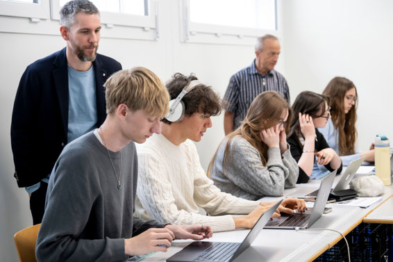 Gymnasiasten_Gymnasiastinnen_Gymnasium_Immensee_am_Laptop_Erprobung_Webapp_Fliehen_vor_dem_Holocaust_Lehrpersonen_beobachten_im_Hintergrund