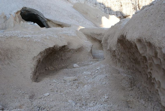 Der untere Teil des Gletschers ist mit Sand und Schutt bedeckt, das Gletschertor mündet in einen Eiskanal