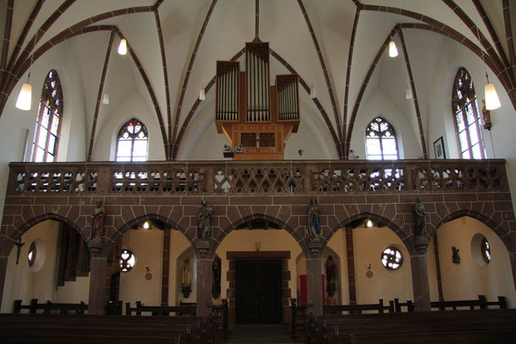 Pfarrkirche - Empore mit Orgel. Der Chor singt auf einer Tribüne, die sich zwischen der Orgel und der an der Wand befestigten Statue der Heiligen Cäcilia befindet. (Foto: Richard Seer, Wiltingen)