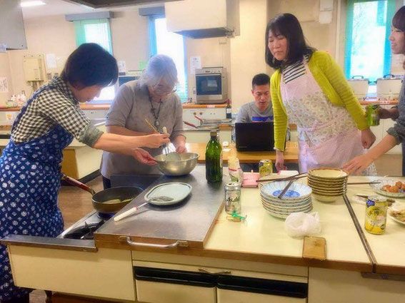 協力して料理している向こうでは記録も?