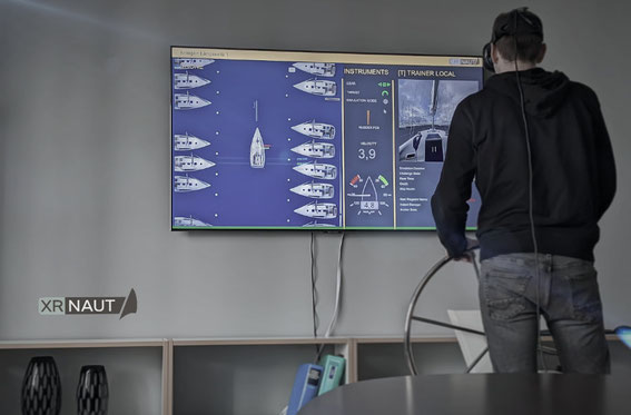 Mensch mit VR-Brille am Steuerstand des Yachtsimulators im Hintergrund Bildschirm