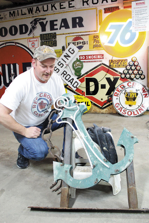 Brian “Beaver” Kueter works on the old neon sign from former Anchor Inn in Bellevue.