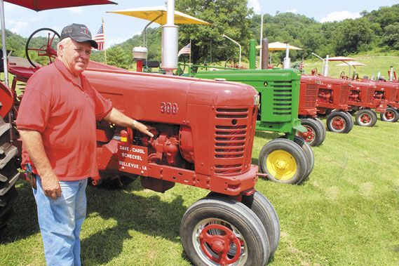 Dave Scheckel is pictured here on Mill Creek Road with 17 classic tractors he has restored over the decades.
