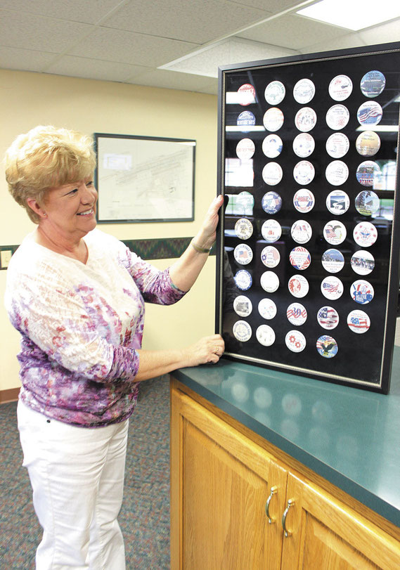 Bellevue City Clerk Janet Callaghan shows off her collection of Heritage Days Buttons that date back to the early 1960s.
