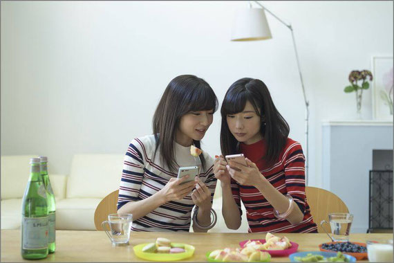 仲良くスマホをいじる女性