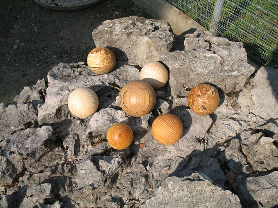 Verschiedene Holzkugeln auf Stein