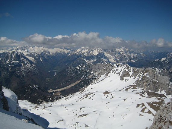 Der Blick nach Westen zum Kanin (links) und in die Wischberggruppe (Bildmitte), im Vordergrund der Kessel in dem die Mangarthütte liegt