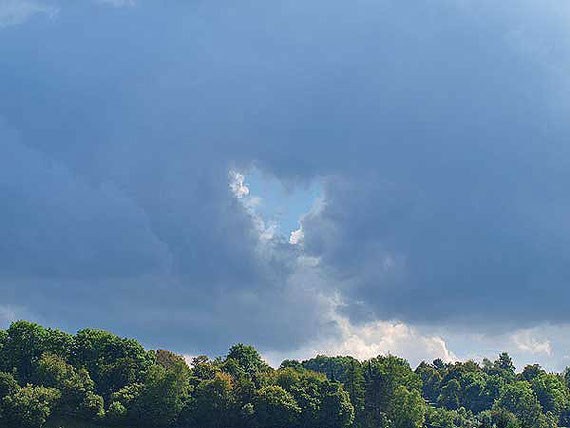 Herzförmige Wolkenöffnung vor einem Gewitter über St. Johann Schwäbische Alb