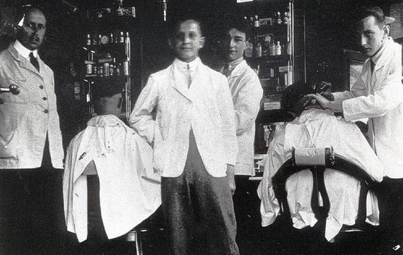 Burchard Cain (Mitte) mit seinen Angestellten in seinem Friseursalon