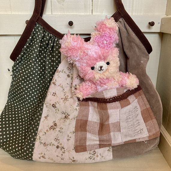 ふわふわピンクのうさぎのあみぐるみが、バッグのポケットかたぴょこん