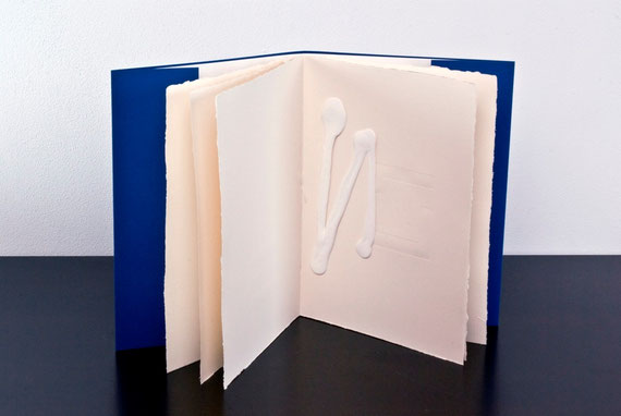 il libro aperto con l'opera bianca su pagina stampata a secco