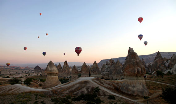 Bei Sonnenaufgang im Heissluftballon über die Tuffsteinlandschaft Kappadokiens schweben.