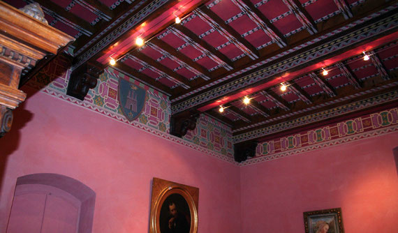 La sala rossa. Grande soffitto a cassettoni decorato "alla maniera della casa fiorentina rinascimentale", con temi geometrici e colorazioni riprese da Palazzo Davanzati a Firenze