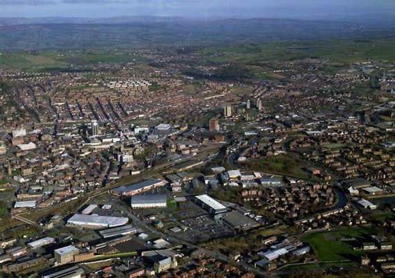 Ariel view of Blackburn town centre and beyond; Pendle Hill nestled amongst the Pennine foothills to the North West