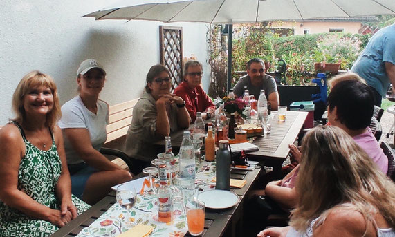 beinamputiert-was-geht Treffen bei Jutta in Mittelhessen. 8 Menschen sitzen um einen Tisch herum und erzählen. Auf dem Tisch stehen Getränke und es wird gegrillt.