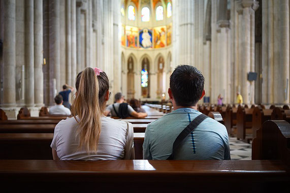 Ein Mann und eine Frau sitzen in einer Kirche