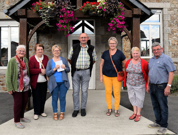La pose photo des gagnants devant l'entrée de la salle des associations