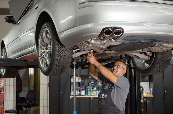 KFZ Wartung und Reparatur - Fahrzeug auf der Hebebühne wird untersucht.