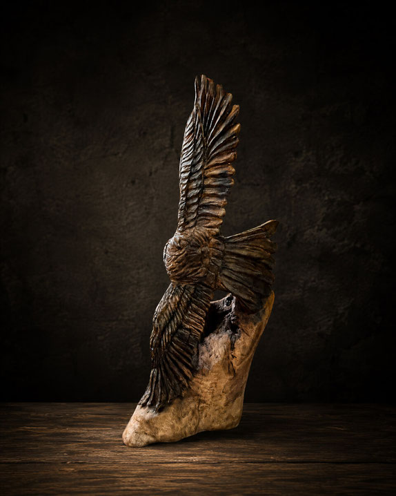 Holzskulptur eines jagenden Adlers mit Hase von Jess Black kunstvoll geschnitzt in atmosphärischer Szene