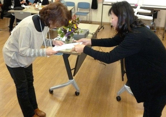 校長先生(右)から修了証を受け取る生徒さん。みのお市民活動センター(かやの中央)で。