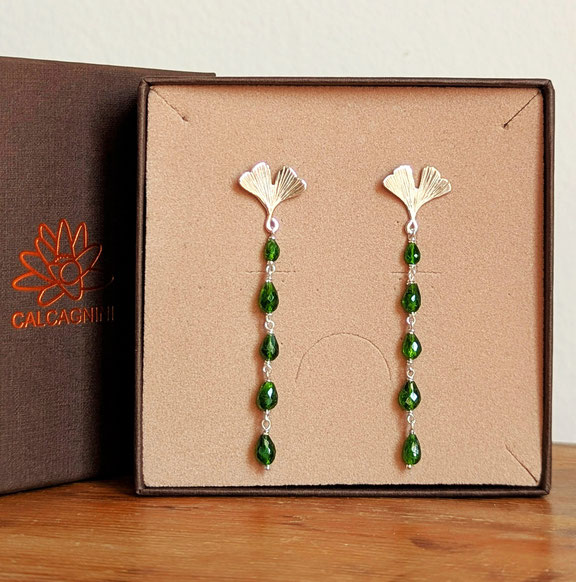 Ogni orecchino è composto da una foglia di ginkgo biloba realizzata e incisa a mano, dalla quale pende una cascata di gocce concatenate di cromo diopside. Gli orecchini hanno una lunghezza di circa 6 cm; i cromo diopsidi sono naturali e di ottima qualità.