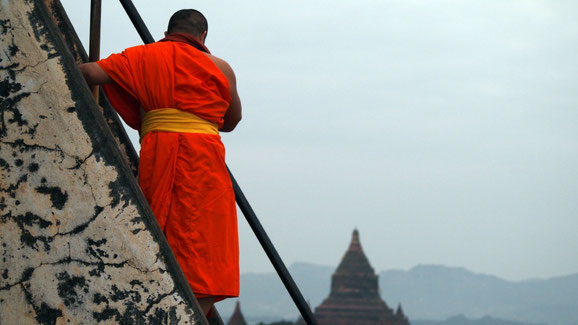Thai monk climbing the temple