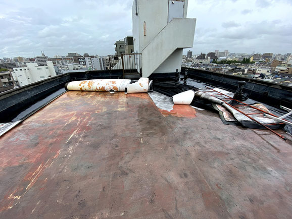 江東区賃貸マンション-屋上防水工事。強風でゴムシートがめくれ防水層損傷。修繕のためゴムシートを撤去中。