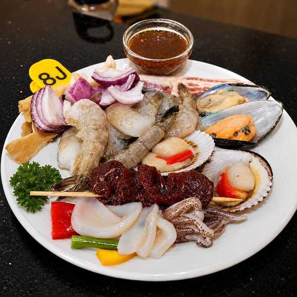 Teppanyaki-Buffet mit Garnelen, Muscheln, Fleisch und frischem Gemüse
