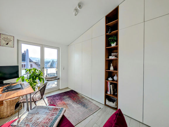 Raumhoher Einbauschrank nach Maß unter einer Dachschräge mit offenem Regal in Villingen-Schwenningen
