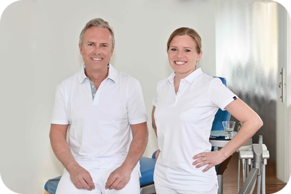 Kieferorthopäde Dr. Wiesner und Zahnärztin Ost sitzen im Behandlungsraum der neu renovierten Praxis Kieferorthopädie Gröbenzell.