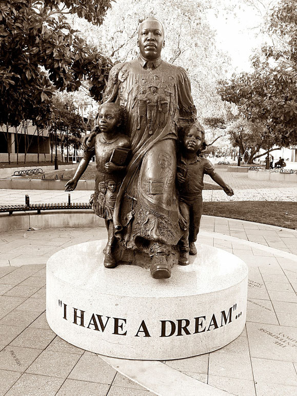 A bronze statue depicts a man with two children, standing on a pedestal inscribed with "I HAVE A DREAM" in bold letters.