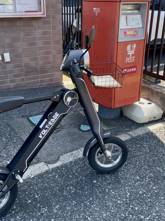 ブレイズ SMART EV に前カゴを装着し、郵便ポスト前に停めている様子。