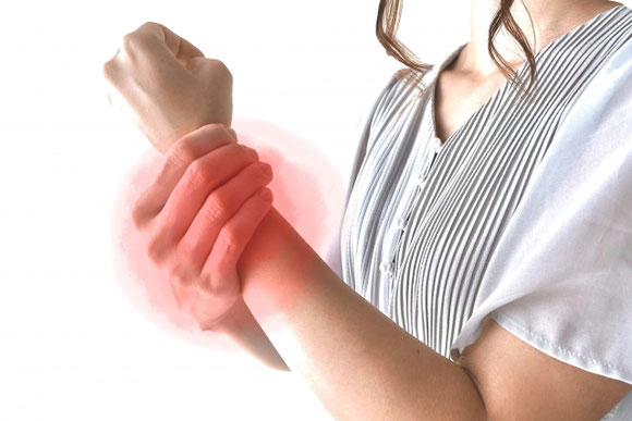 手首や指の痛みを感じ、手を休めている女性｜腱鞘炎による痛みや不快感で悩んでいる方へ