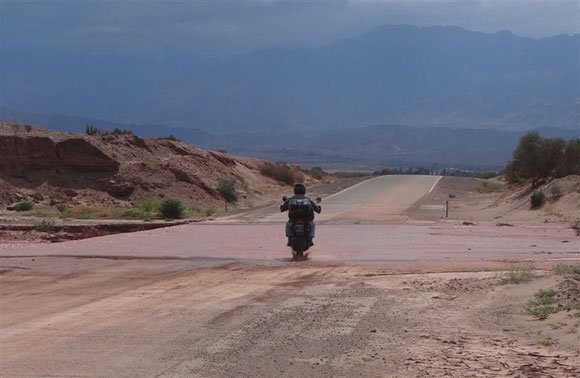 An dem Tag haben wir nur eine Gruppe an Motorradfahrern gesehen; der erste testet gerade die Furt. Zu dem Zeitpunkt wußten wir noch nicht, welche Auswirkung die dunkle Wand im Hintergrund haben wird. Wir selber sind nämlich nicht naß geworden ...