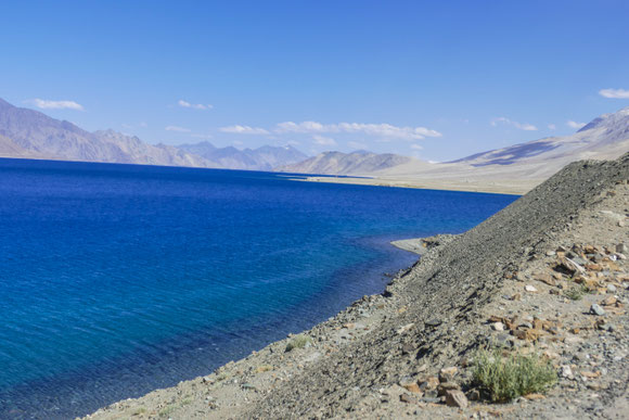 Und dann, nach einer Kurve liegt er plötzlich vor uns - der Pangong Lake! Irgendwo in der Ferne kreuzt die Chinesische Grenze den See.