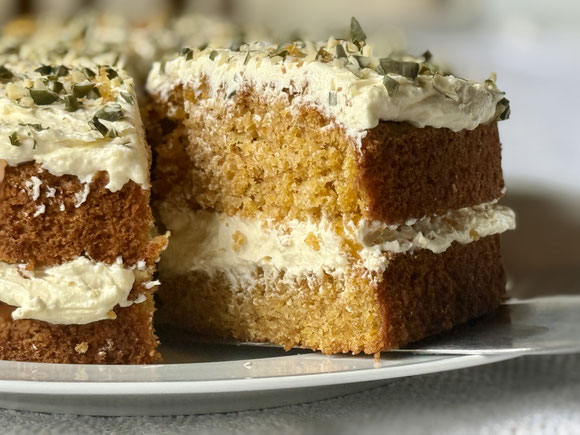 Saftiger Karottenkuchen mit Buttercreme gefüllt und getoppt – frisch und einladend serviert