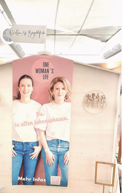 Großes Roll-up mit Markenbotschaft von One Woman’s Life am Messestand – Teil des visuellen Auftritts und der Messegestaltung