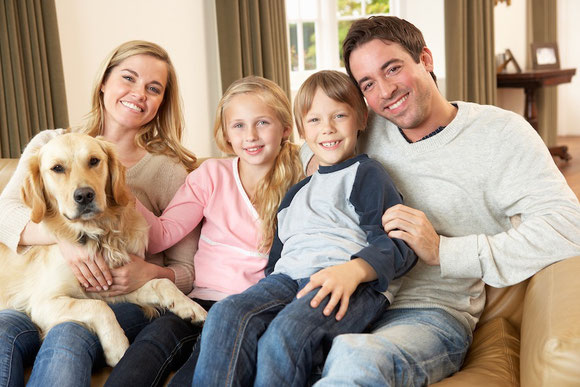 Family sitting a on couch smiling because wealth accumulation planning worked