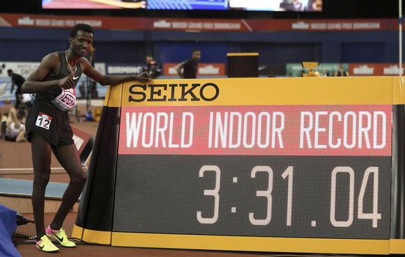 Samuel Tefera, de Etiopía, junto al indicador de tiempo, mientras celebra el récord mundial en pista cubierta de 1500 metros durante el Gran Premio Indoor de Muller en Birmingham, Inglaterra, el sábado 16 de febrero de 2019. (David Davies / PA AP)