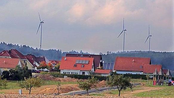 Blick von der Wohnsiedlung „Rhönblick“ (Neubaugebiet am Lüderberg) in Bad Salzschlirf auf drei der fünf Windindustrieanlagen des „Windparks Wartenberg“.