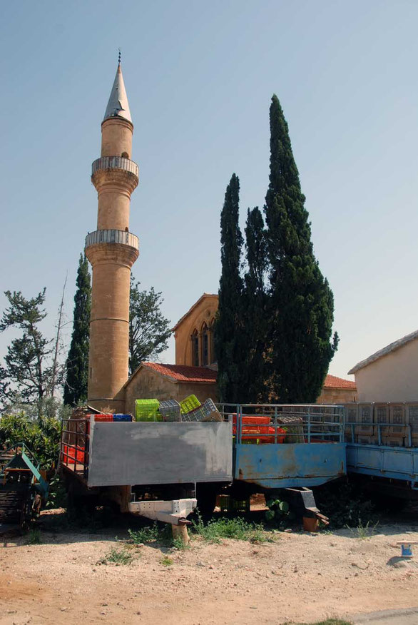 One of Cyprus' oldest mosques with Cypress trees and trailers at Peristerona