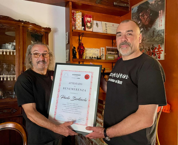 Istantanea del conferimento a Paolo Bertocchi (sx) da parte del residente Enrico Neami (dx).